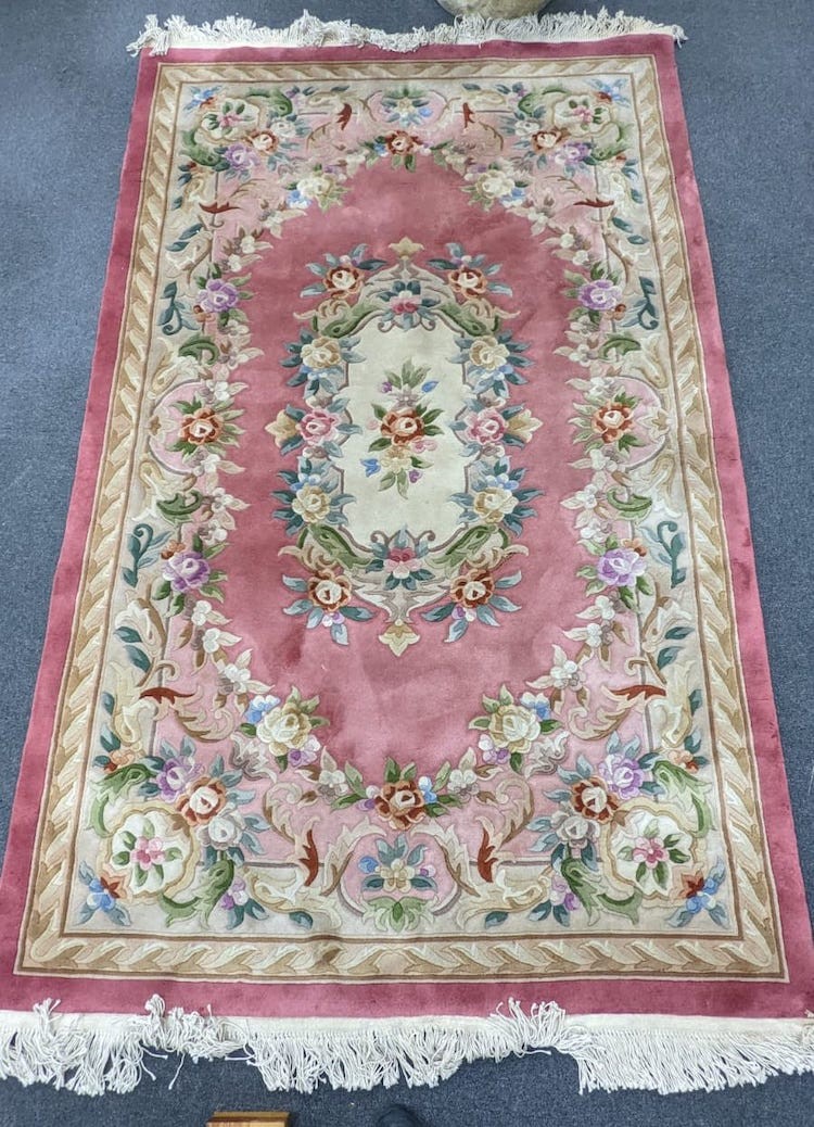 A Chinese pink ground embossed carpet, 244 x 150cm